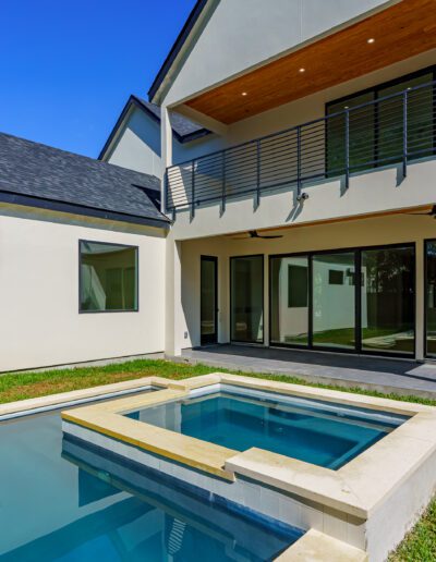 Modern two-story home with a pool and outdoor balcony.