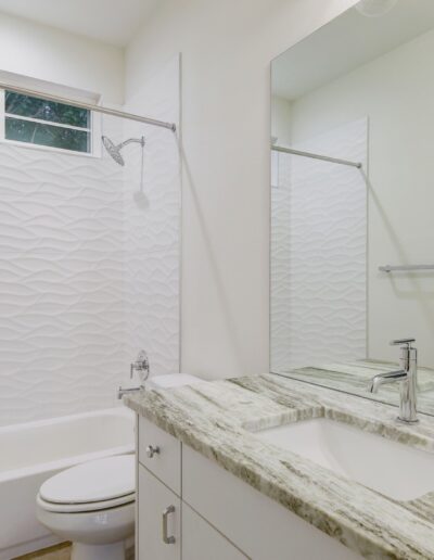 Modern bathroom interior with textured wall and marble countertop.