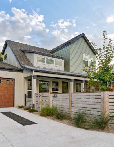 Modern two-story house with a wooden garage door and a white concrete driveway.