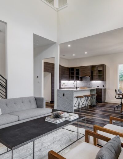 Modern living room with minimalist decor leading to an open-concept kitchen area.